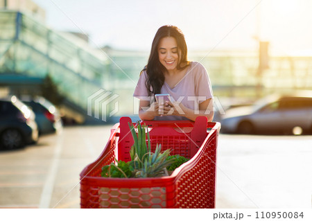 Woman with phone and cart in sunlight Woman with phone and cart in sunlight 110950084