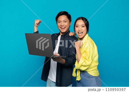 Glad millennial asian couple in casual rise fist, celebrate win, success with laptop Glad millennial asian couple in casual rise fist, celebrate win, success with laptop 110950397