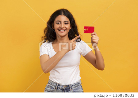 Positive young indian lady showing bank credit card Positive young indian lady showing bank credit card 110950632