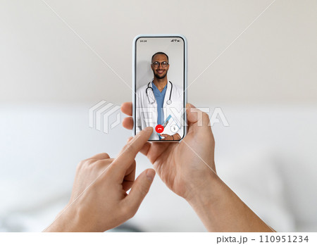 Man at home using smartphone for an online health consultation with doctor Man at home using smartphone for an online health consultation with doctor 110951234