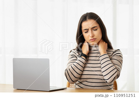 Sad tired young arab woman work at computer, suffer from pain in neck, health problems, feeling bad Sad tired young arab woman work at computer, suffer from pain in neck, health problems, feeling bad 110951251