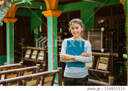 smiling young Asian businesswoman carrying clipboard smiling young Asian businesswoman carrying clipboard 110951313