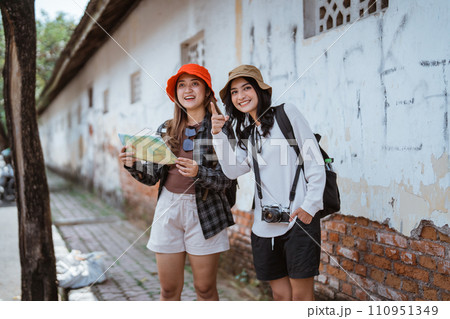 Asian girl local tourist uses a map to find the way 110951349