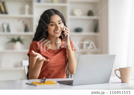 Cheerful young indian woman entrepreneur working from home 110951555