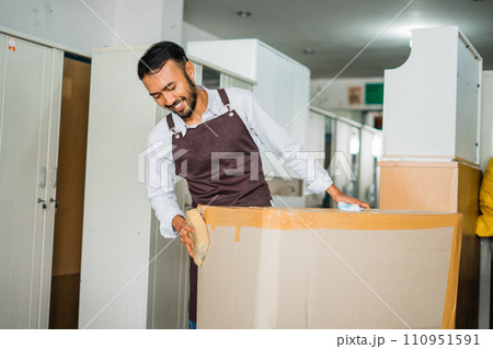 male shop assistants pack ordered furniture using cardboard boxes before sending male shop assistants pack ordered furniture using cardboard boxes before sending 110951591