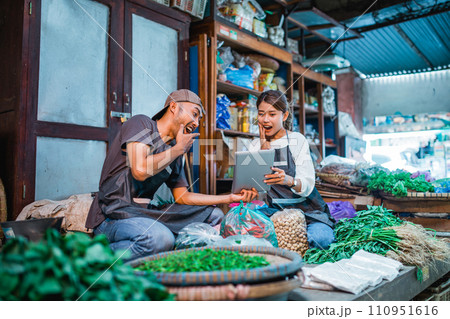 vegetable sellers looked surprised while holding tablet 110951616