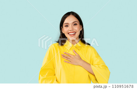 Happy young woman touching her chest and smiling Happy young woman touching her chest and smiling 110951678