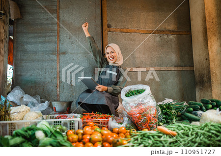 asian vegetable seller holding tablet with fist pump gesture asian vegetable seller holding tablet with fist pump gesture 110951727