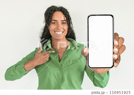 black lady points at large phone display on white background black lady points at large phone display on white background 110951925