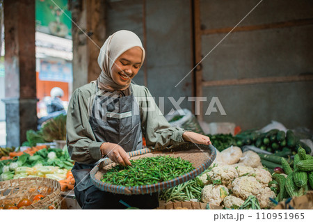 asian female seller checking vegetable product asian female seller checking vegetable product 110951965
