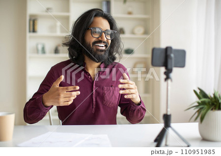 Young Indian Male Blogger Recording Video At Home With Smartphone On Tripod Young Indian Male Blogger Recording Video At Home With Smartphone On Tripod 110951985