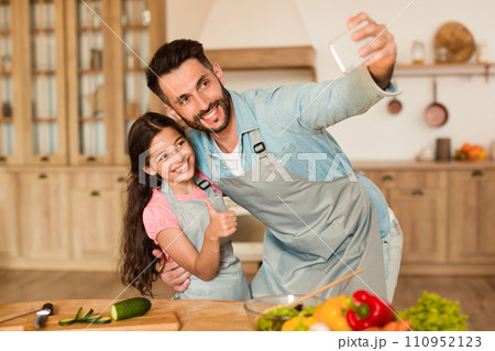 Dad and daughter take selfie while cooking 110952123