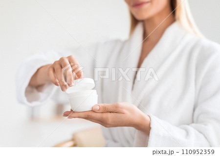 lady holding and opening cosmetic jar with moisturizer cream indoor lady holding and opening cosmetic jar with moisturizer cream indoor 110952359