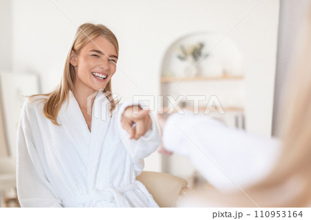 Young woman points to her reflection in mirror in bathroom 110953164