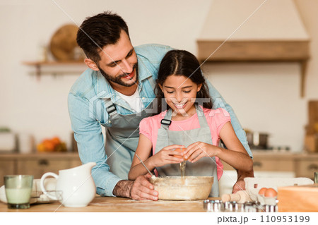 Father and daughter mixing batter together 110953199