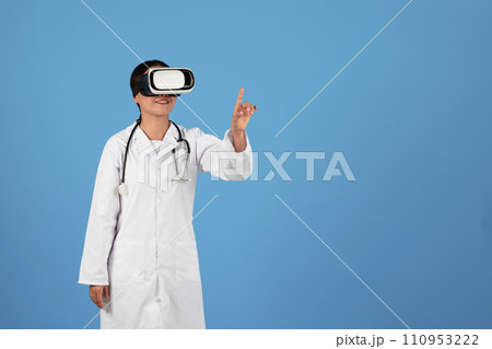 VR Medicine. Asian Doctor Wearing Virtual Reality Headset Standing On Blue Background 110953222