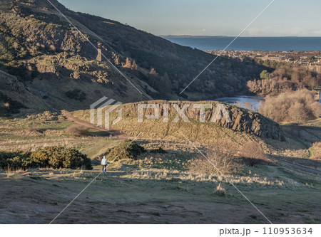 Scenic landscape of Holyrood Park on Salisbury Crags with cityscape of Edinburgh city. 110953634