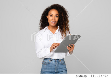 African American lady using her tablet computer for business, studio 110953752
