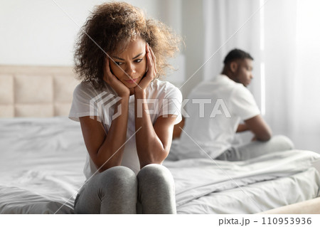 Unhappy Black Couple Sitting On Different Sides Of Bed Indoor 110953936