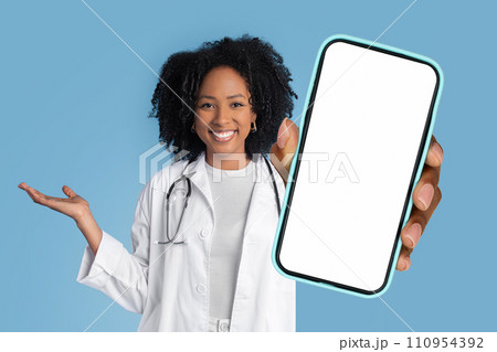 lady physician showing mobile phone with empty touchscreen, blue background 110954392