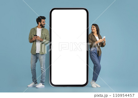 Stylish young indian man and woman using phones Stylish young indian man and woman using phones 110954457
