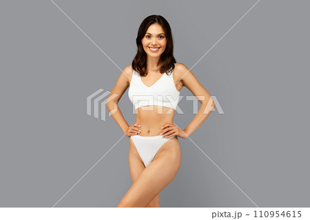 Positive caucasian slim young woman in white underwear show perfect body after weight loss Positive caucasian slim young woman in white underwear show perfect body after weight loss 110954615
