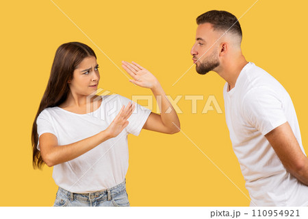 Angry millennial european woman in white t-shirt stop man, wants kiss 110954921