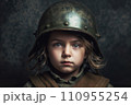A young boy wearing an old military uniform and helmet, staring into the camera. A young boy wearing an old military uniform and helmet, staring into the camera. 110955254
