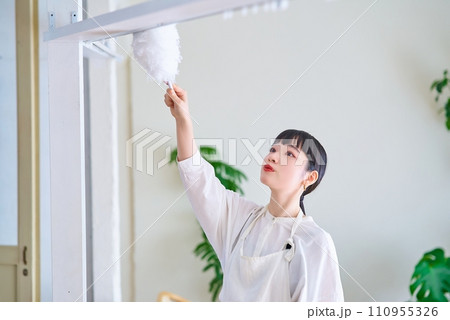 部屋の隅々の埃を掃除する若い女性 部屋の隅々の埃を掃除する若い女性 110955326
