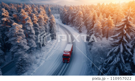 a large red lonely truck drives along the road through the endless winter forest a large red lonely truck drives along the road through the endless winter forest 110957022