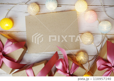 Empty Paper Caft with LED cotton balls and gift boxes on wooden background 110957140