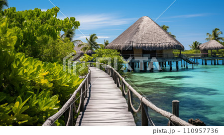 Wooden path leading to thatched-roof bungalows over turquoise sea surrounded by lush greenery Wooden path leading to thatched-roof bungalows over turquoise sea surrounded by lush greenery 110957736