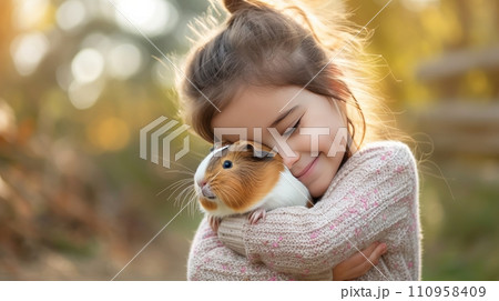 Little girl holding a cute guinea pig in her arms Little girl holding a cute guinea pig in her arms 110958409