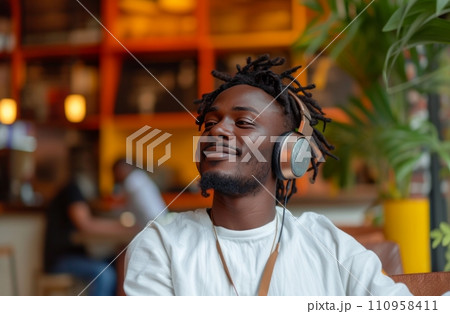 man in headphones in a cafe with white shirt listening to music 110958411