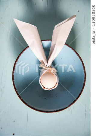 egg wrapped in easter bunny shaped napkin 110958850