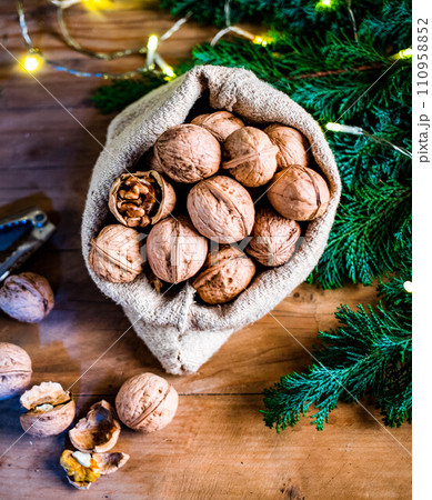festive christmas nuts tumbling from a burlap bag 110958852