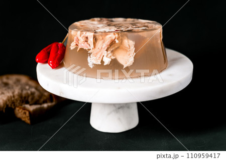Jelly with meat, beef aspic, traditional dish. portion on plate. Bread and chili. 110959417