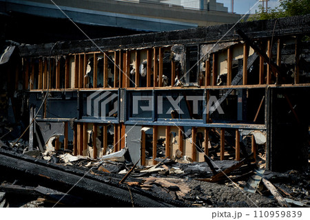 A burnt-out old wooden building after a fire. Charred beams after the destruction. 110959839