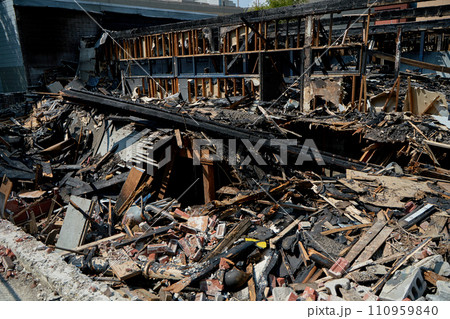 A burnt-out old wooden building after a fire. Charred beams after the destruction. 110959840