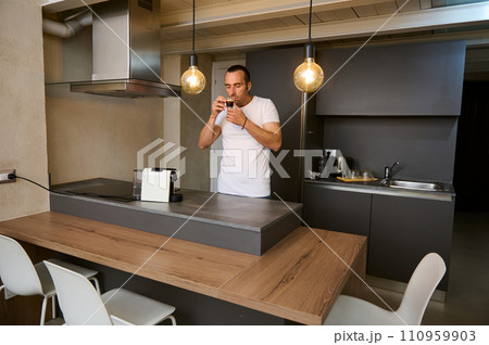 Young adult man drinking coffee at home 110959903