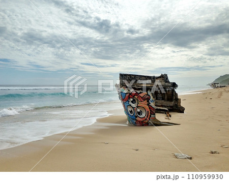 The wreckage of a wooden ship on a sandy beach on the ocean. The shipwreck 110959930