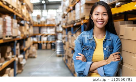 Portrait of female warehouse worker standing in large bright distribution center with ample lighting 110960793