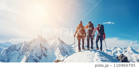 Friends climbing together, supporting each other as a team to reach the mountain summit. 110960795