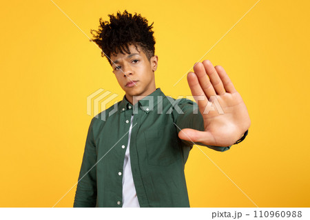 Serious tired young black man showing stop gesture 110960988