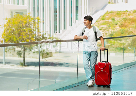 Young asian man tourist with suitcase, phone in his hand 110961317