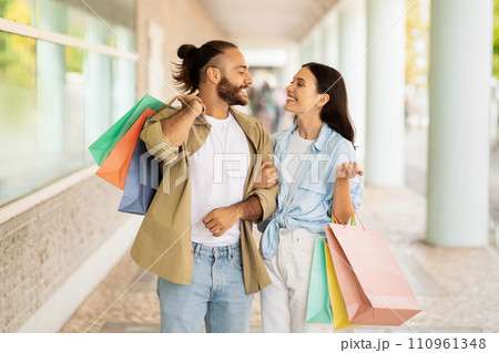 Satisfied millennial caucasian lady and guy shopaholics with many packages 110961348