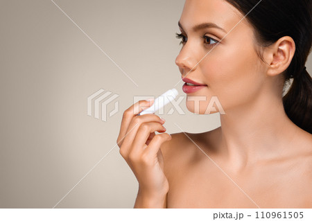 Calm millennial european lady with perfect skin apply lip balm, enjoy routine procedures 110961505