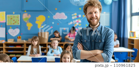 Smiling male teacher leading elementary school class with students learning in background 110961825