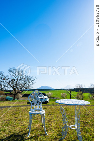 青空光芒と阿蘇山を背景にガーデンテーブル風景(売店・レストラン)「うぶやま牧場(阿蘇郡産山村)」 110962728