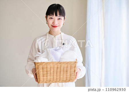 洗濯物を持つ若い女性 110962930